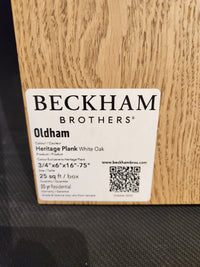 Label on wood sample: "Beckham Brothers Heritage Plank White Oak" premium hardwood flooring with QR code.