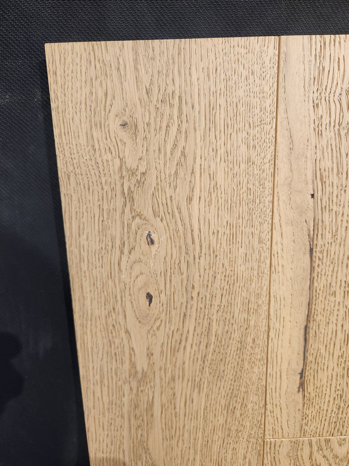 Beckham Brothers Heritage Plank White Oak: light-colored panels with visible grain and knots, shown on a dark background.