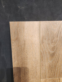 Light brown Little Ben XL Luxury Vinyl by Beckham Brothers with wood texture and 9X Coating on a dark textured background.
