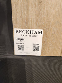 A sample "Little Ben XL Luxury Vinyl" plank by Beckham Brothers with QR codes sits on a textured surface.