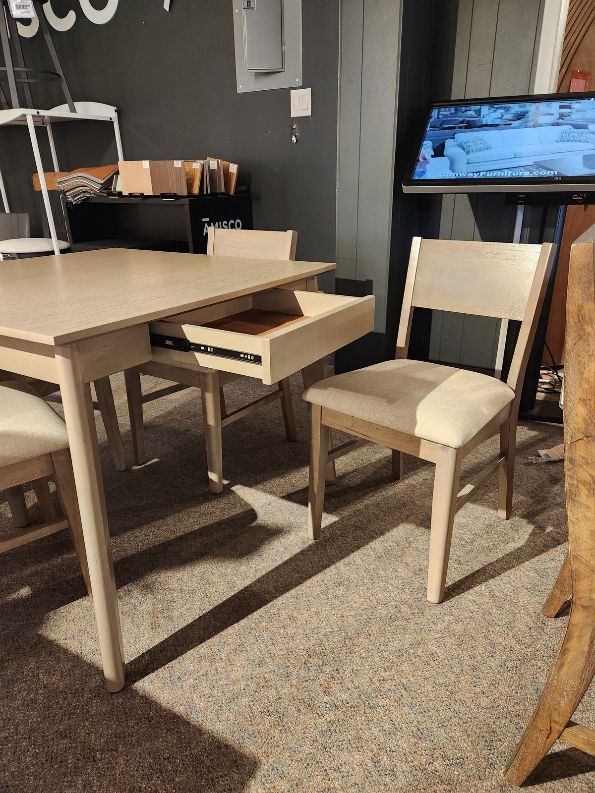 The York Dining Set by Donald Choi features a dining table with storage and a matching lightly-cushioned chair.