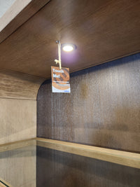 A light with a Honey Wheat finish illuminates the Magnussen D5878 Tristan LT. Brown Dining Cabinet’s wooden shelf.