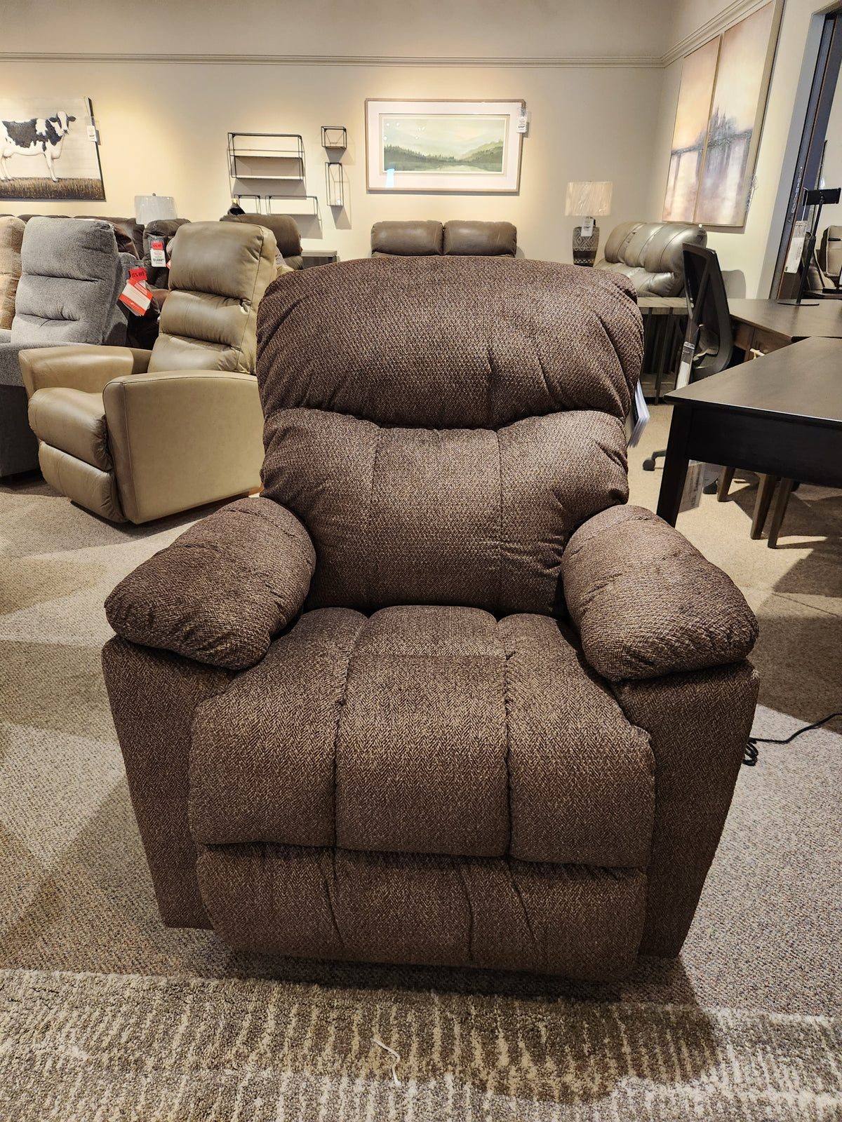 The La-z-boy 766 Morrison Power XR Recliner is showcased in a showroom with other chairs in the background.