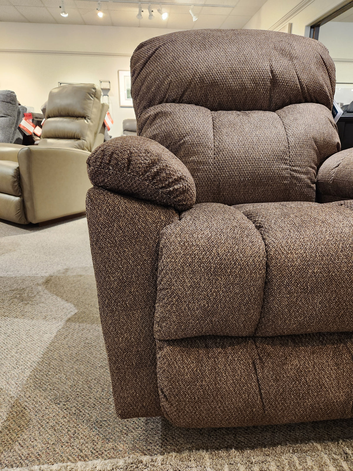A La-Z-Boy 766 Morrison Power XR Recliner is on display in a showroom with other chairs in the background.