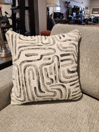 A square, textured pillow with a geometric pattern sits on the Decor-rest 2456 3-Piece Sectional in the showroom.