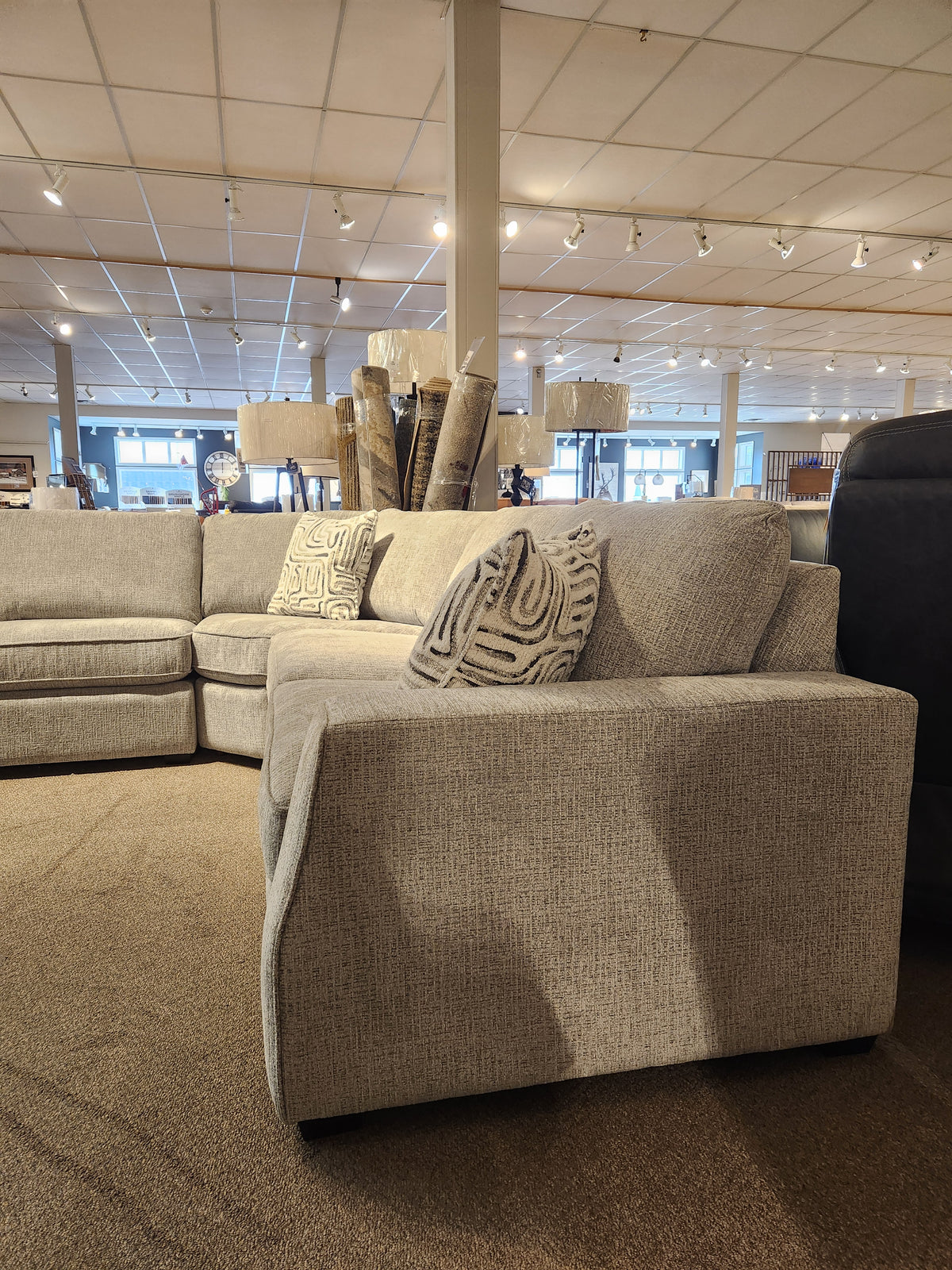 Decor-rest 2456 3-Piece Sectional in light gray with patterned pillows, displayed in a carpeted showroom.