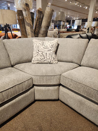 The Decor-rest 2456 3-Piece Sectional with a decorative pillow is showcased in a showroom with lamps and rugs.
