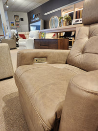 Palliser 43411 Baltic 2 Power Swivel Glider recliner in brown leather with tilting headrest, shown in a chic showroom.