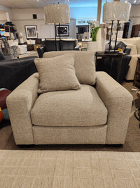 Donald Choi Laguna Chair: Beige upholstered armchair with square arms and matching pillow in a modern showroom.