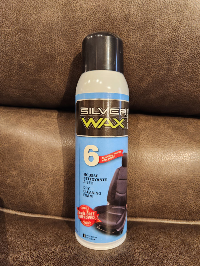 A can of Eric Cox Spray Carpet Cleaner sits on a brown leather surface.