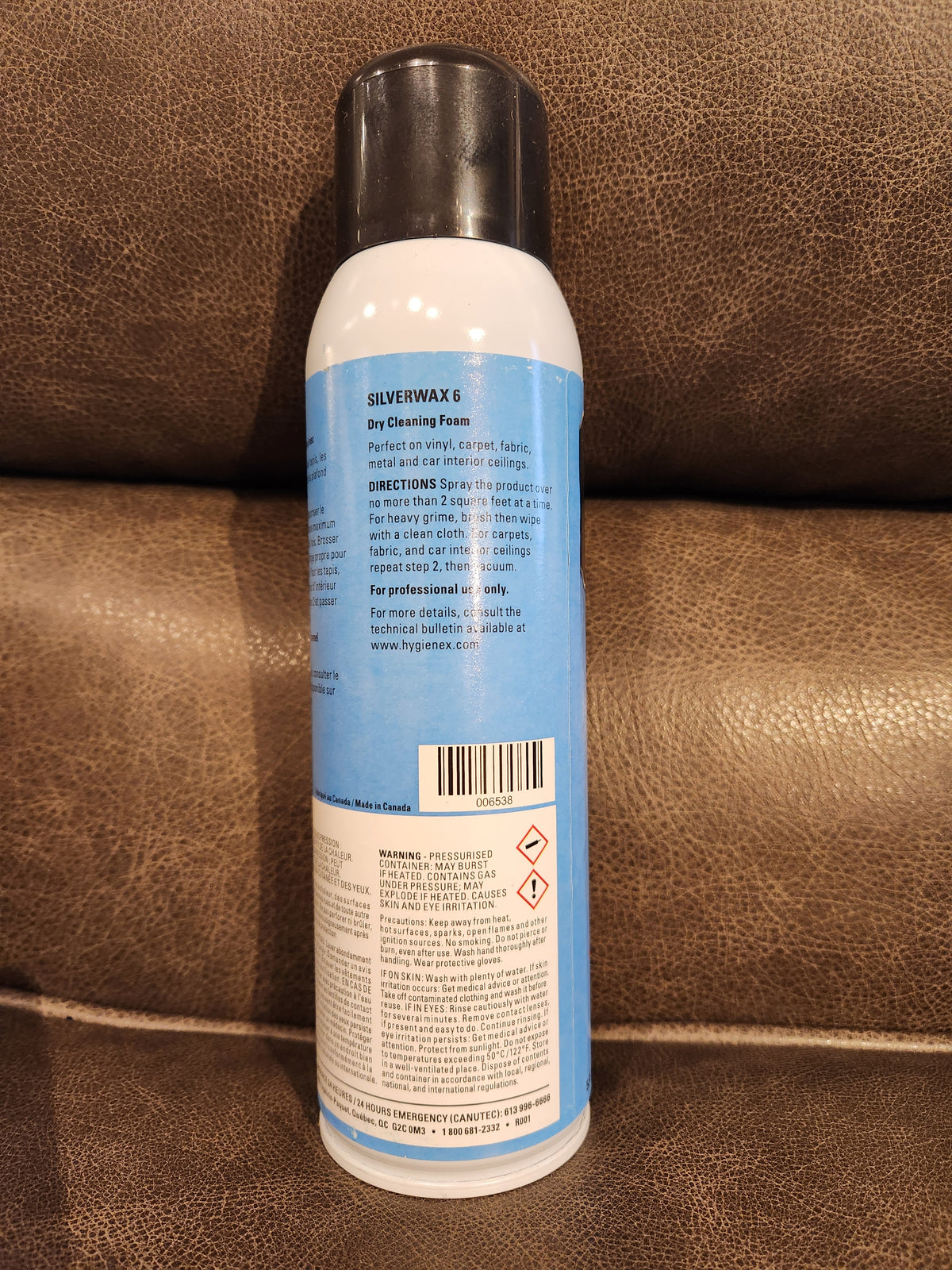 A can of Eric Cox Spray Carpet Cleaner with instructions and warnings on the back, placed on a brown surface.