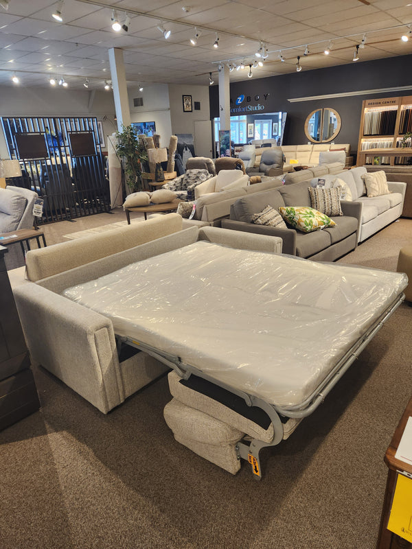 A Simmons Upholstery 9350 Queen Sofa Bed with track arms is shown fully extended in a furniture showroom.