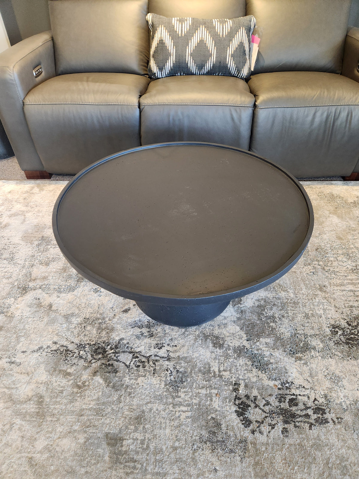 The Maru 32" Coffee Table by Donald Choi sits on a patterned rug in front of a gray sofa with a decorative pillow.