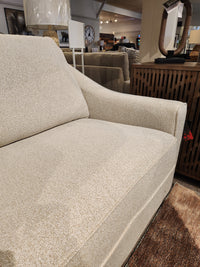 Close-up of the Decor-rest 2981 Sofa in beige, featuring box seat cushions beside a wooden cabinet in a showroom.