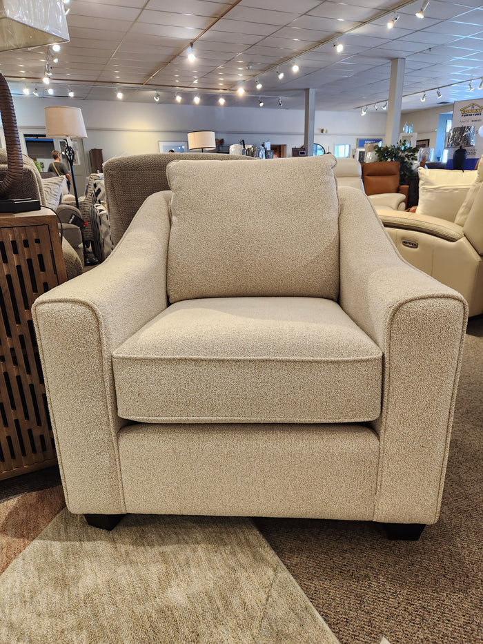 The Decor-rest 2981 Chair, beige upholstered with box seat cushions and square arms, is on display in the showroom.