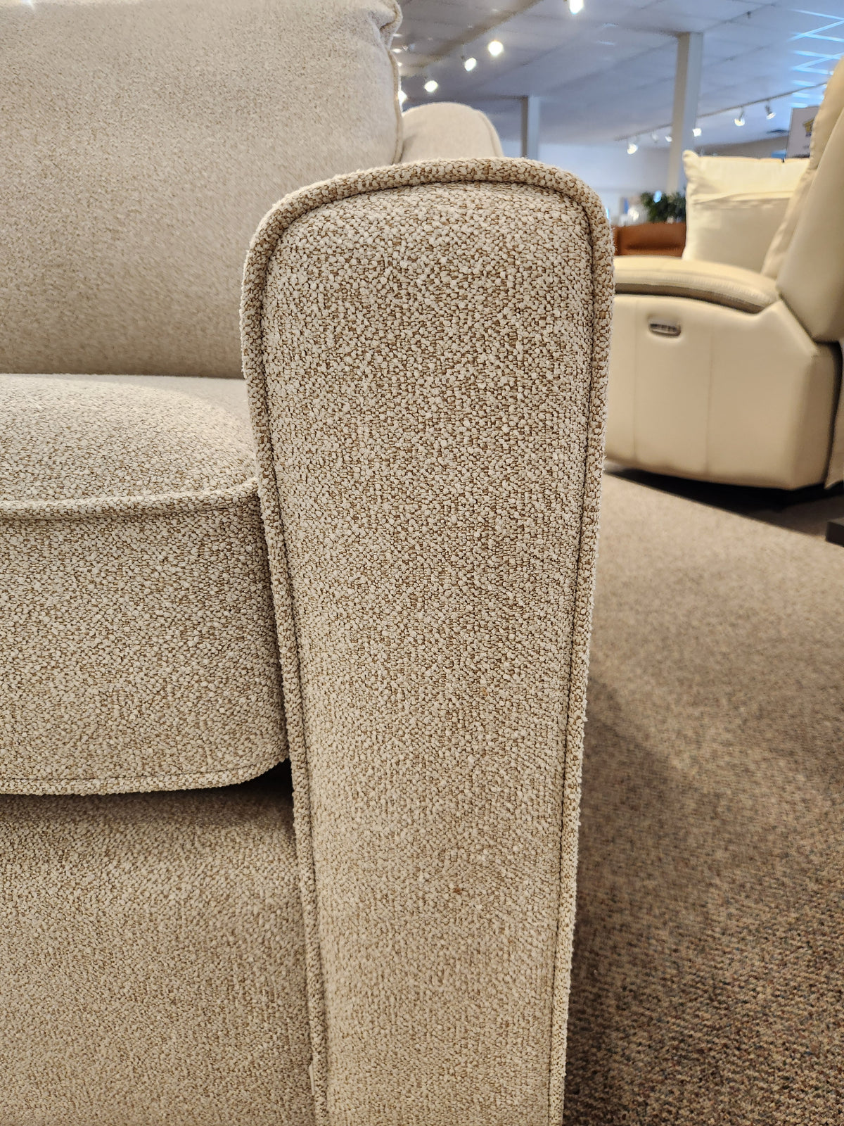 Close-up of the armrest and box seat cushions of the Decor-rest 2981 Chair in light beige with sinuous springs.