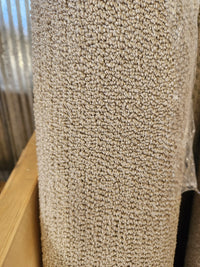 Close-up of Flooring CLEARANCE Carpet Remnant 4'9" x 6', taupe, looped low pile, rolled and stored vertically in store.