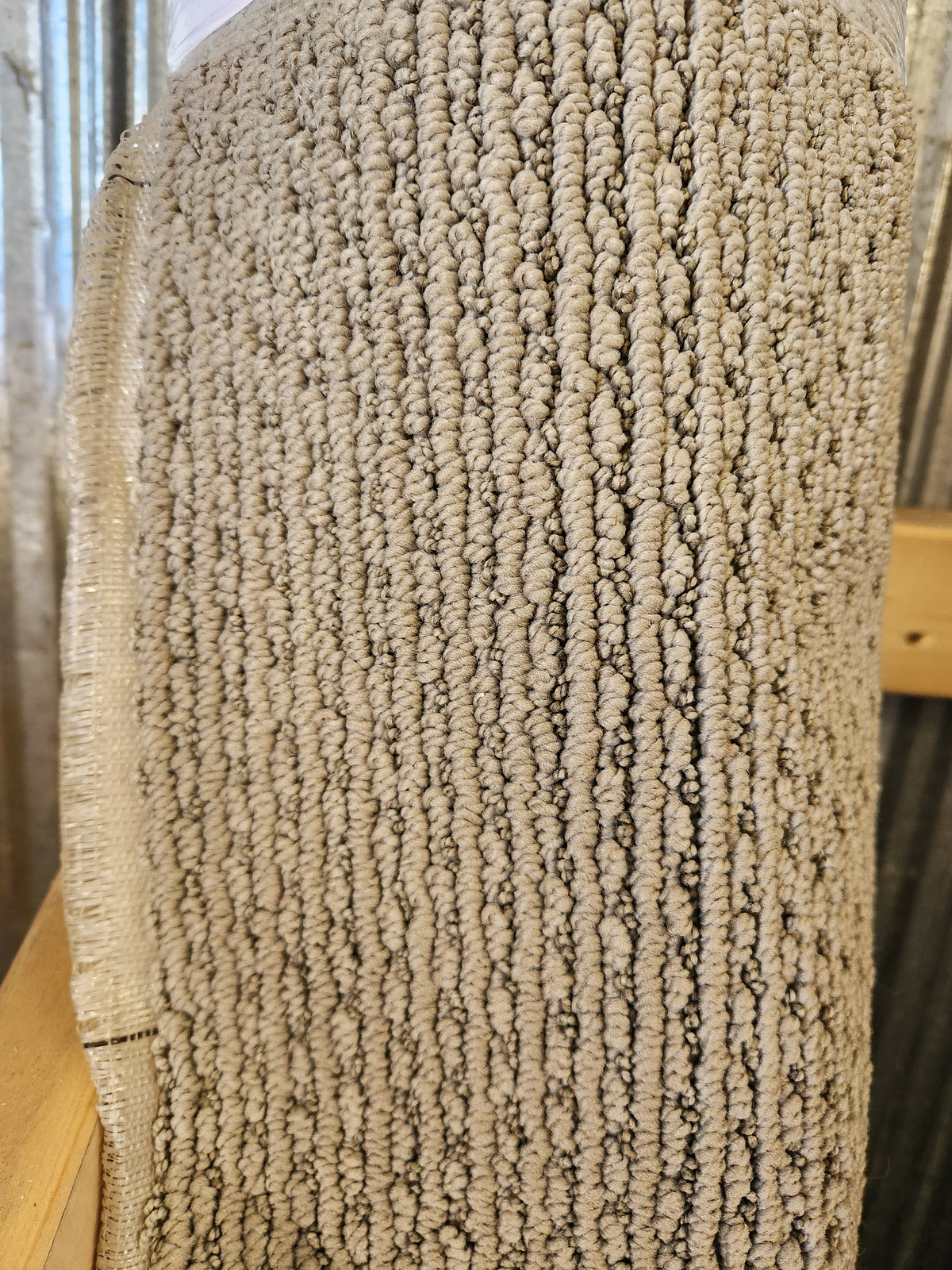 Close-up of Flooring CLEARANCE Carpet Remnant 12' X 5' edge with stitching on wood and metal surfaces.