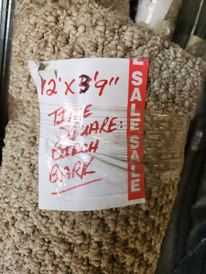 A beige Carpet Remnant 12' X 3'9" by Flooring CLEARANCE with a red "SALE" sticker on the side.