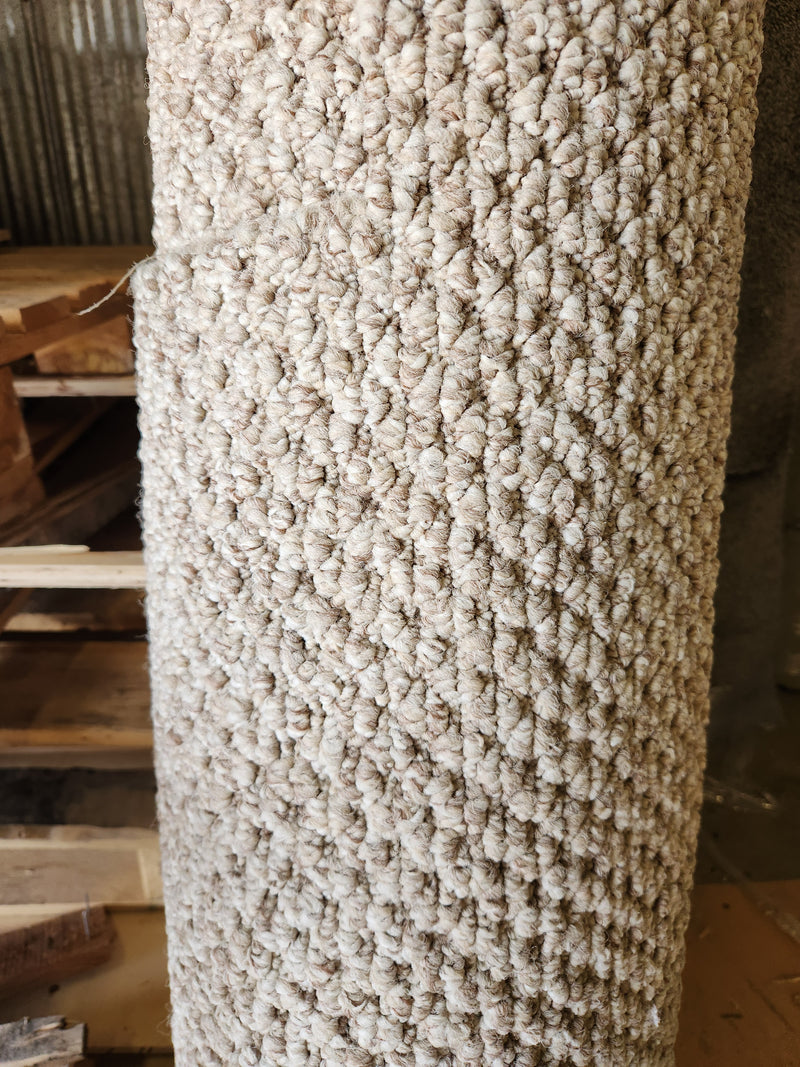 A Carpet Remnant 12' X 3'9" by Flooring CLEARANCE stands rolled up next to stacked wooden pallets.