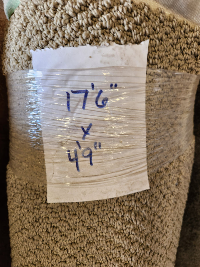 A rolled beige Carpet Remnant 17'6" x 4'9" by Flooring CLEARANCE with label showing dimensions.