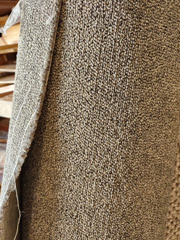 Close-up of Flooring CLEARANCE Carpet Remnant 3'4" x 21'6", beige low pile with frayed edge on left.