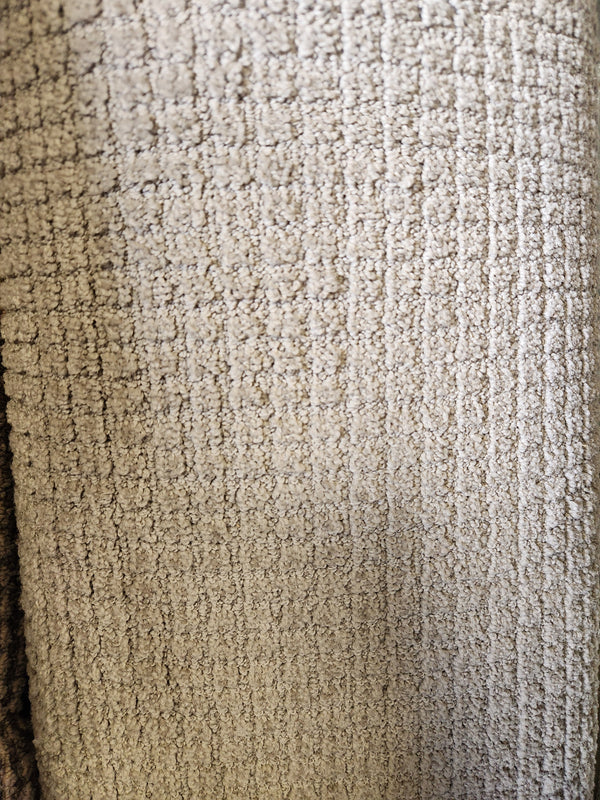 Close-up of Flooring CLEARANCE Carpet Remnant 12' X 6'4", showing textured beige grid pattern and visible fibers.