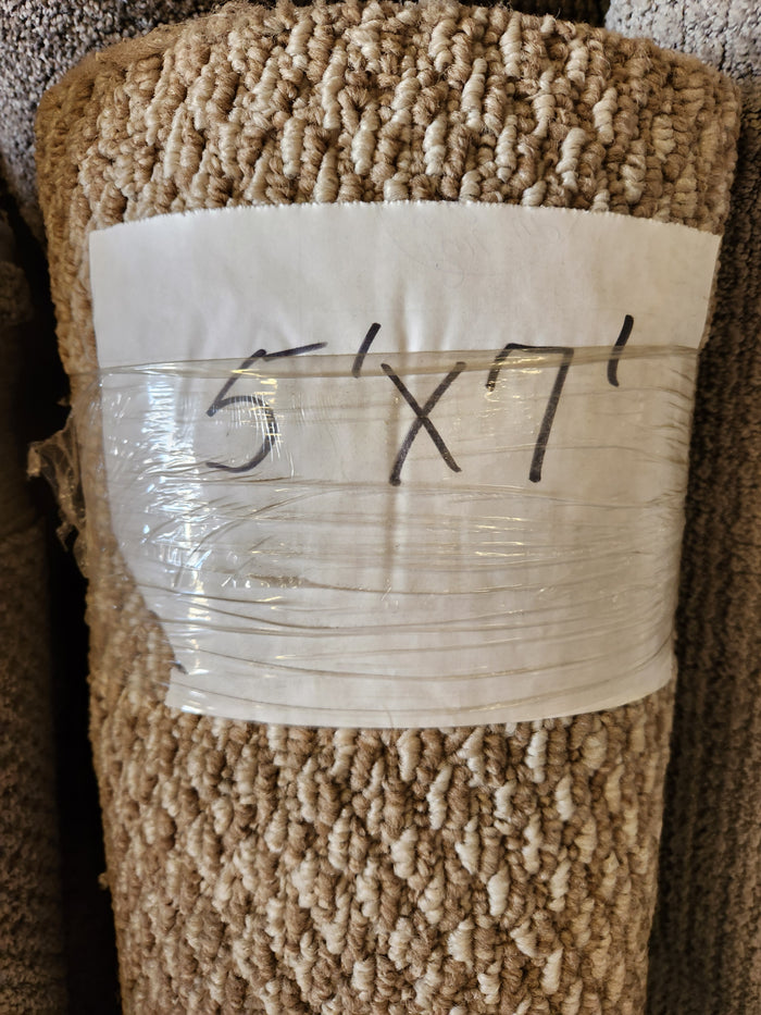 A Flooring CLEARANCE Carpet Remnant 5' x 7', light beige low pile, rolled and wrapped in clear plastic.