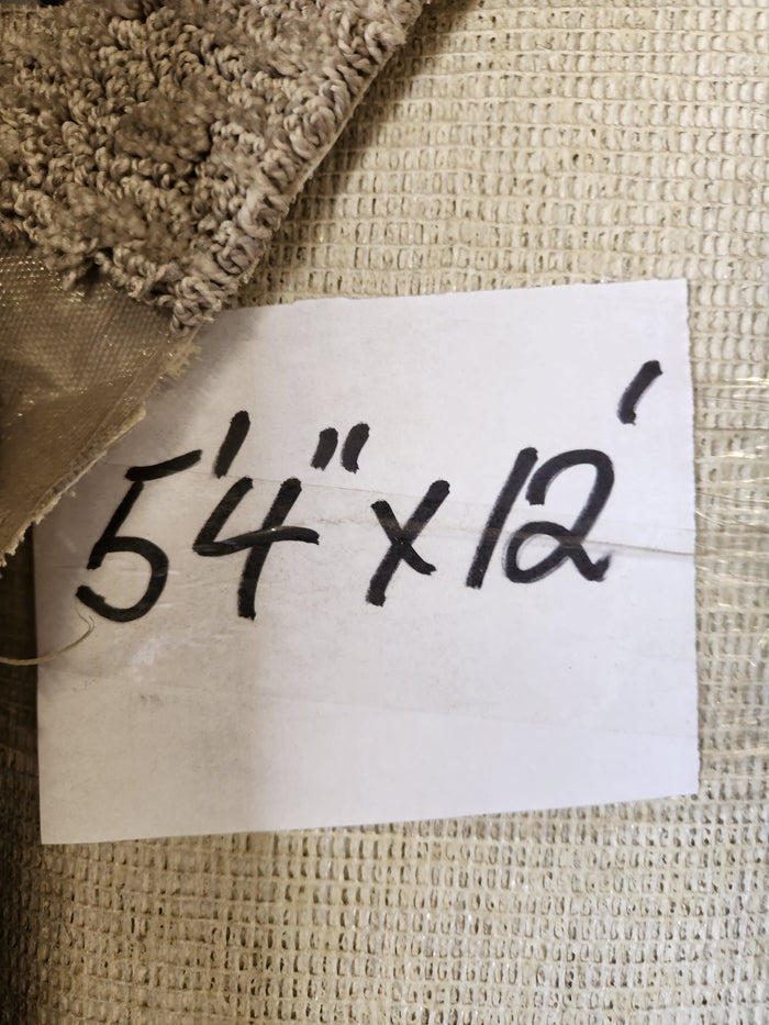 A handwritten label "5'4\" x 12'" sits on a Flooring CLEARANCE Carpet Remnant, grey with medium pile.