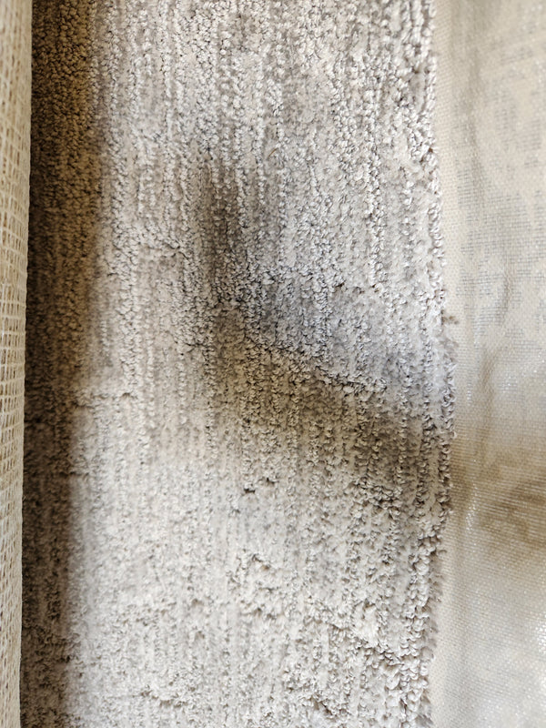 Close-up of Flooring CLEARANCE Carpet Remnant 5'4" X 12', medium pile grey with a dark irregular mark in the center.