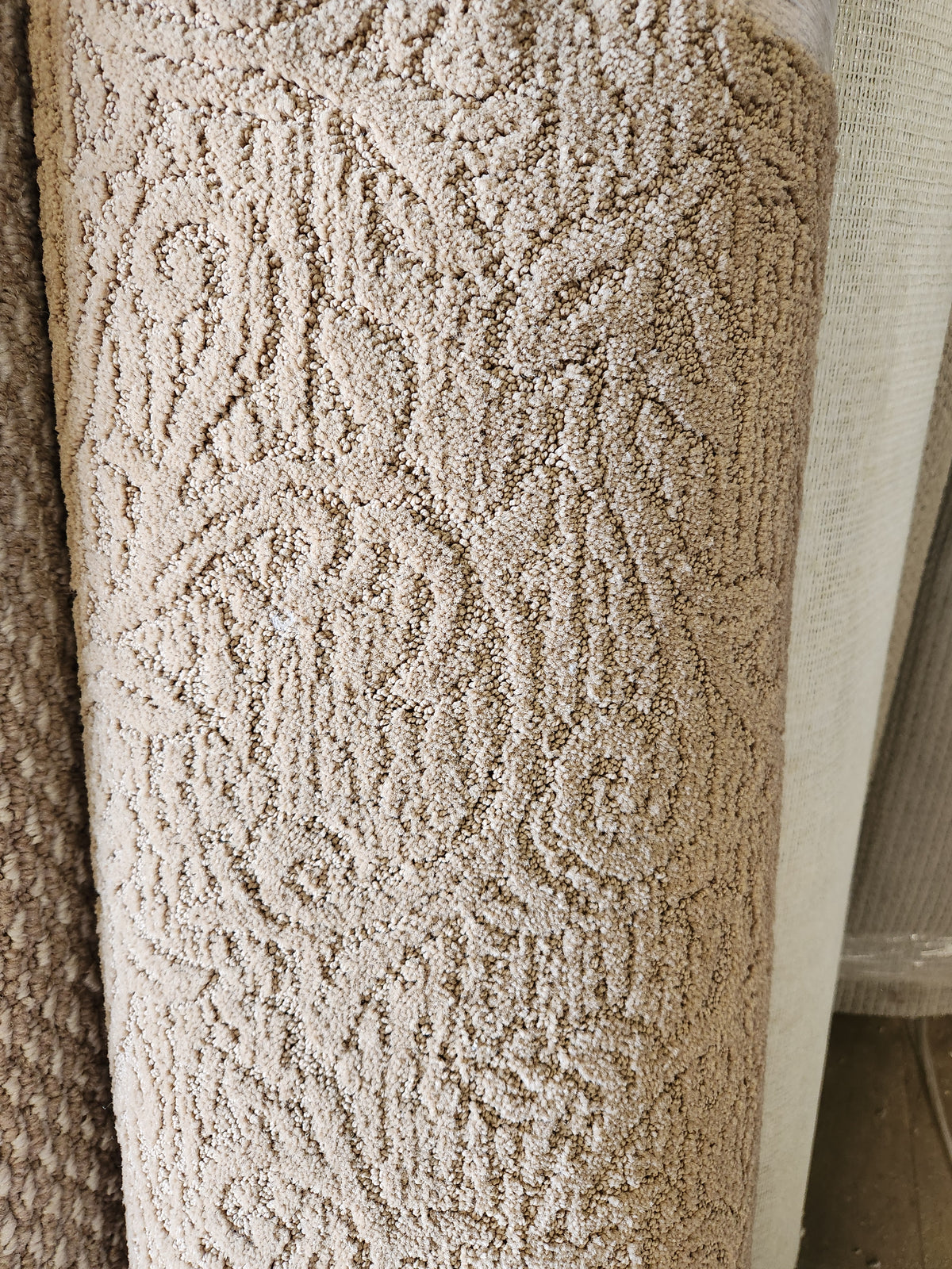 Close-up of a Flooring CLEARANCE Carpet Remnant 5' X 13' in tan, with another Bohemian rug roll in the background.