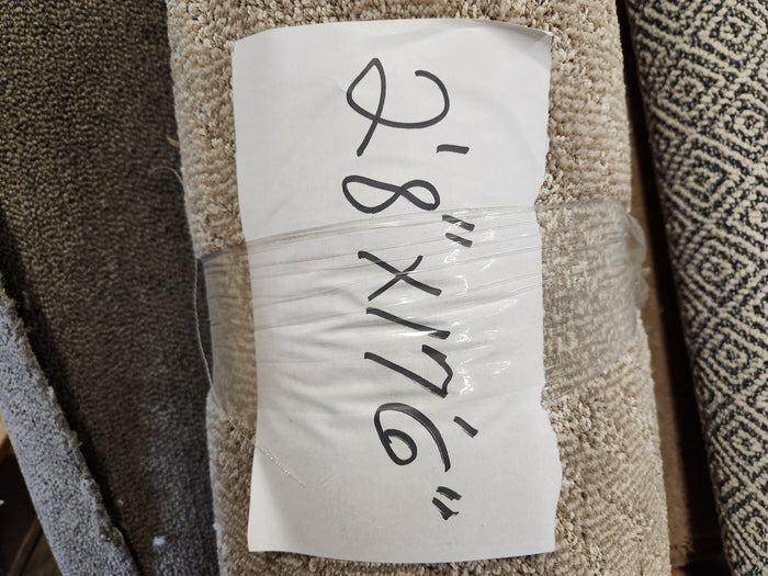 A Carpet Remnant 2'8" X 7'6" by Flooring CLEARANCE, rolled with a handwritten size label taped to it.