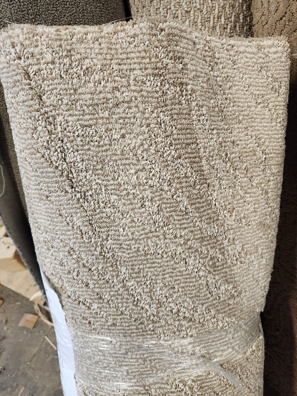 A Flooring CLEARANCE Carpet Remnant 2'8" X 7'6" roll, wrapped in plastic, rests among other carpet rolls in-store.