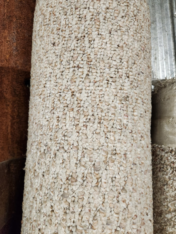 Close-up of Flooring CLEARANCE Carpet Remnant 8'4" X 10'4", Light Tan Low Loop Pile, upright by a metal and wood background.