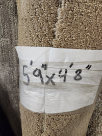 A Flooring CLEARANCE label on a medium pile Carpet Remnant 5'9" X 4'8" is marked in black.