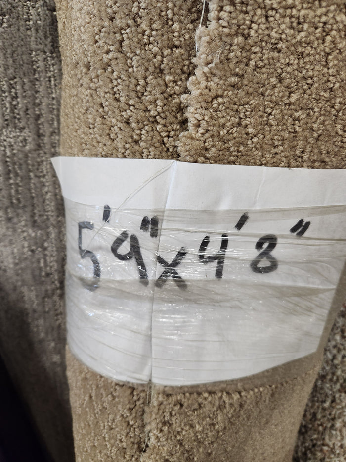 A Flooring CLEARANCE label on a medium pile Carpet Remnant 5'9" X 4'8" is marked in black.
