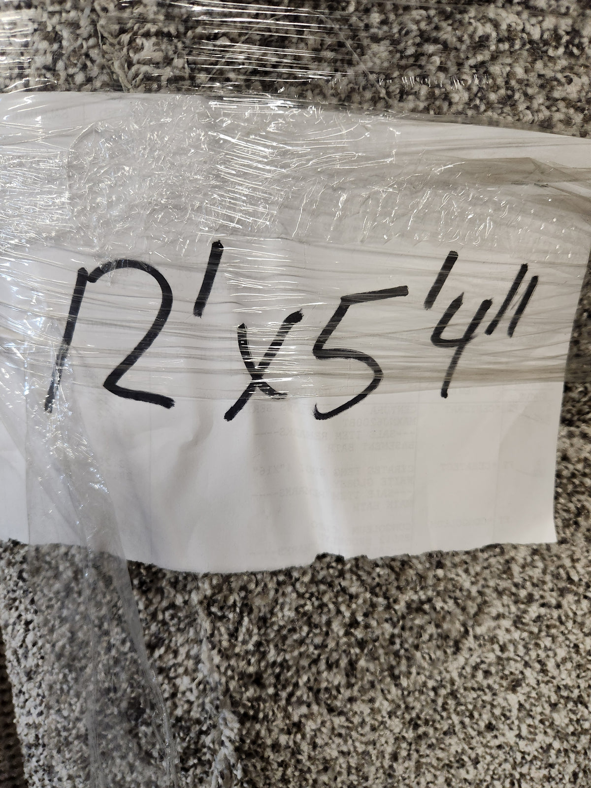 A handwritten sign on the Flooring CLEARANCE Carpet Remnant 12' X 5'4" dark grey rug notes its size in black marker.