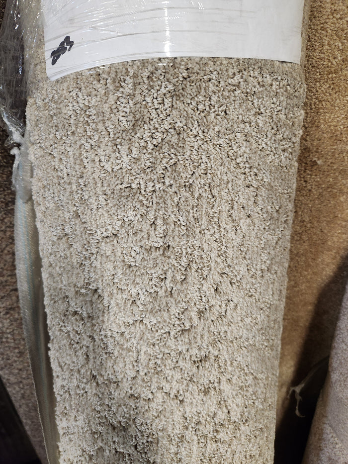 Close-up of Flooring CLEARANCE Carpet Remnant 12' X 5'5", medium pile, light beige, with a white label at the top.