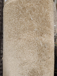 A close-up of Flooring CLEARANCE Carpet Remnant 12' X 6'6" in beige with a soft, textured, medium pile.