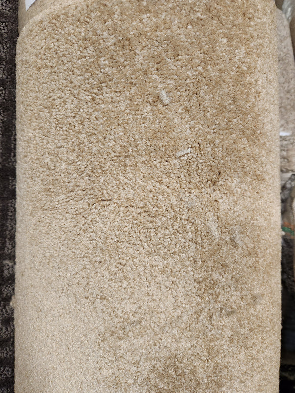 A close-up of Flooring CLEARANCE Carpet Remnant 12' X 6'6" in beige with a soft, textured, medium pile.
