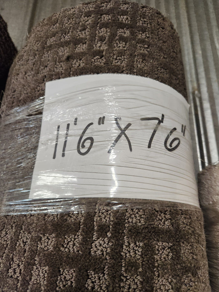 A Flooring CLEARANCE Carpet Remnant 11'6" x 7'6", brown low pile, rolled and wrapped in plastic.