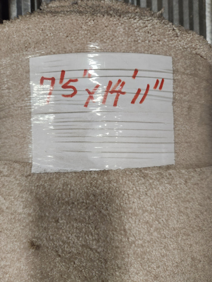 A roll of Flooring CLEARANCE Carpet Remnant 7'5" x 14'11", light beige, medium pile, labeled in red on white tape.