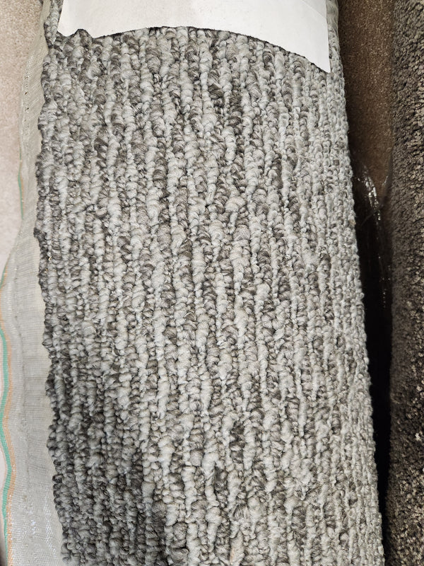 Close-up of Flooring CLEARANCE Carpet Remnant 6' X 10', low loop pile grey with textured fibers and partial white label.