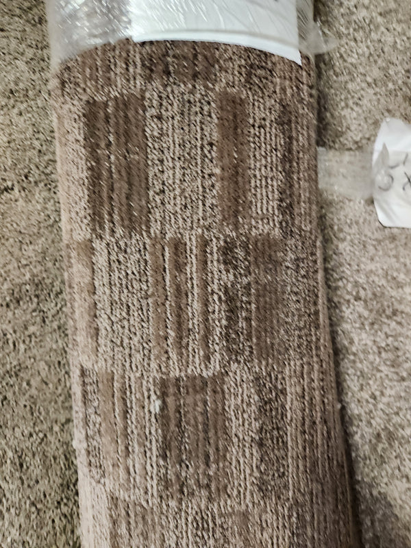 A Flooring CLEARANCE Carpet Remnant 5'10" x 12', dark brown checkered, lies on a beige carpeted floor.