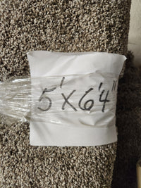 A Flooring CLEARANCE Carpet Remnant 5' X 6'4" with a white paper label marked in black on this plush high pile rug.