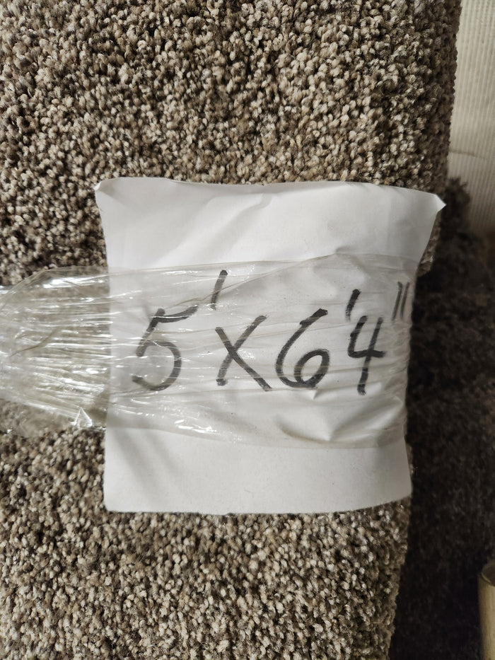 A Flooring CLEARANCE Carpet Remnant 5' X 6'4" with a white paper label marked in black on this plush high pile rug.