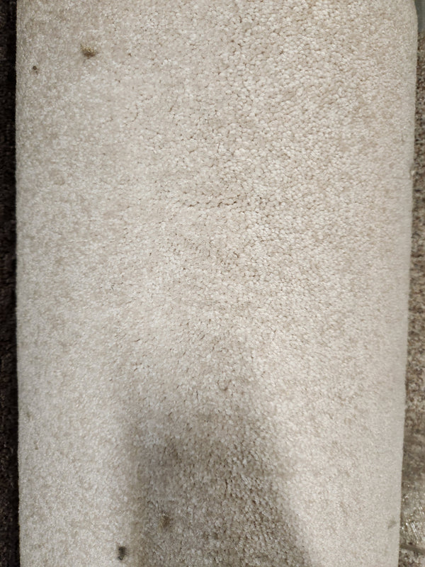 Close-up of Flooring CLEARANCE Carpet Remnant 7'5" x 14'11", medium pile, light beige with minor dirt spots and texture.