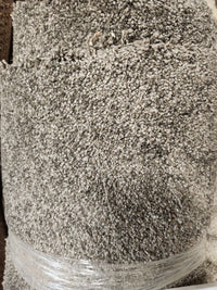 A close-up of Flooring CLEARANCE Carpet Remnant 12' X 5', dark grey, rolled and wrapped in clear plastic.
