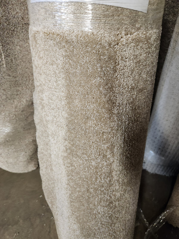 A Flooring CLEARANCE Carpet Remnant 12' X 3'6" stands upright, wrapped in clear plastic for protection.
