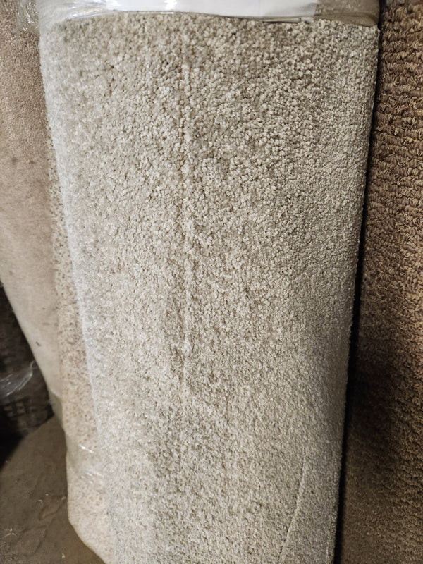 A large roll of Flooring CLEARANCE Carpet Remnant 12' X 3'11" stands upright in a warehouse setting.